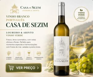 Garrafa de vinho branco português Casa de Sezim Loureiro e Arinto ao lado de uma taça servida e uvas verdes.