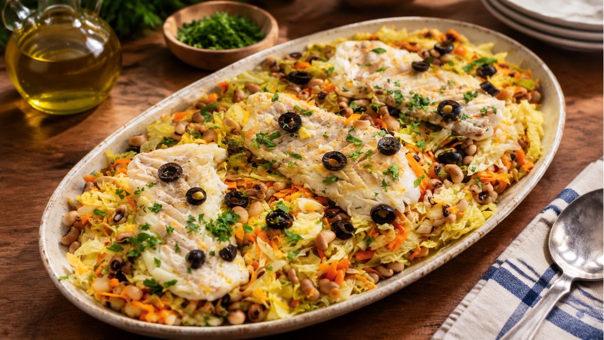Prato de lagarada de bacalhau em lascas sobre salada de feijão frade, couve lombarda, cenoura e azeitonas pretas.
